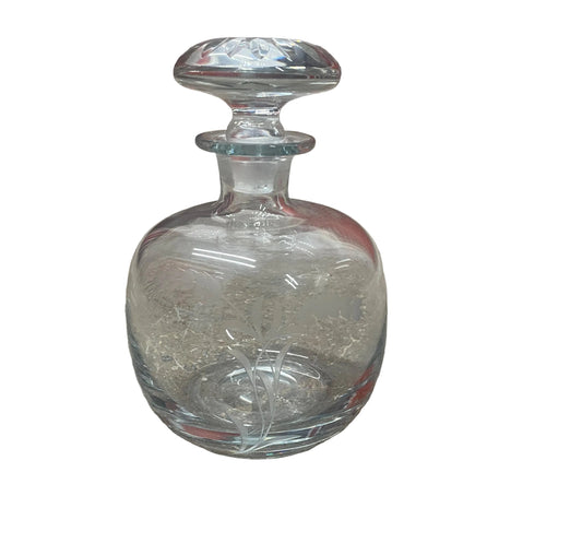 This beautiful vintage Reijmyre clear glass decanter was hand-blown in Sweden and features a delicate etched wheat grass design. It stands 7" tall and measures 4 1/2" wide, making it a perfect size for decanting your favorite spirits or displaying as a decorative piece.